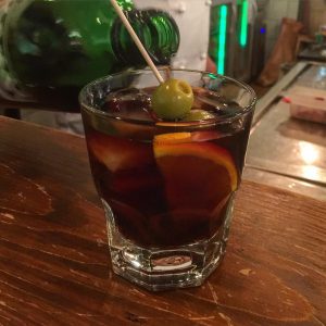 a glass of vermouth with olive