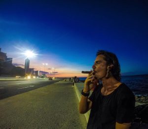 a man smokes a cigar on el malecon havana cuba