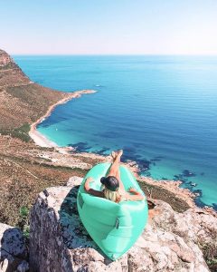 a woman sits in a blow up chair overlooking cape town south africa